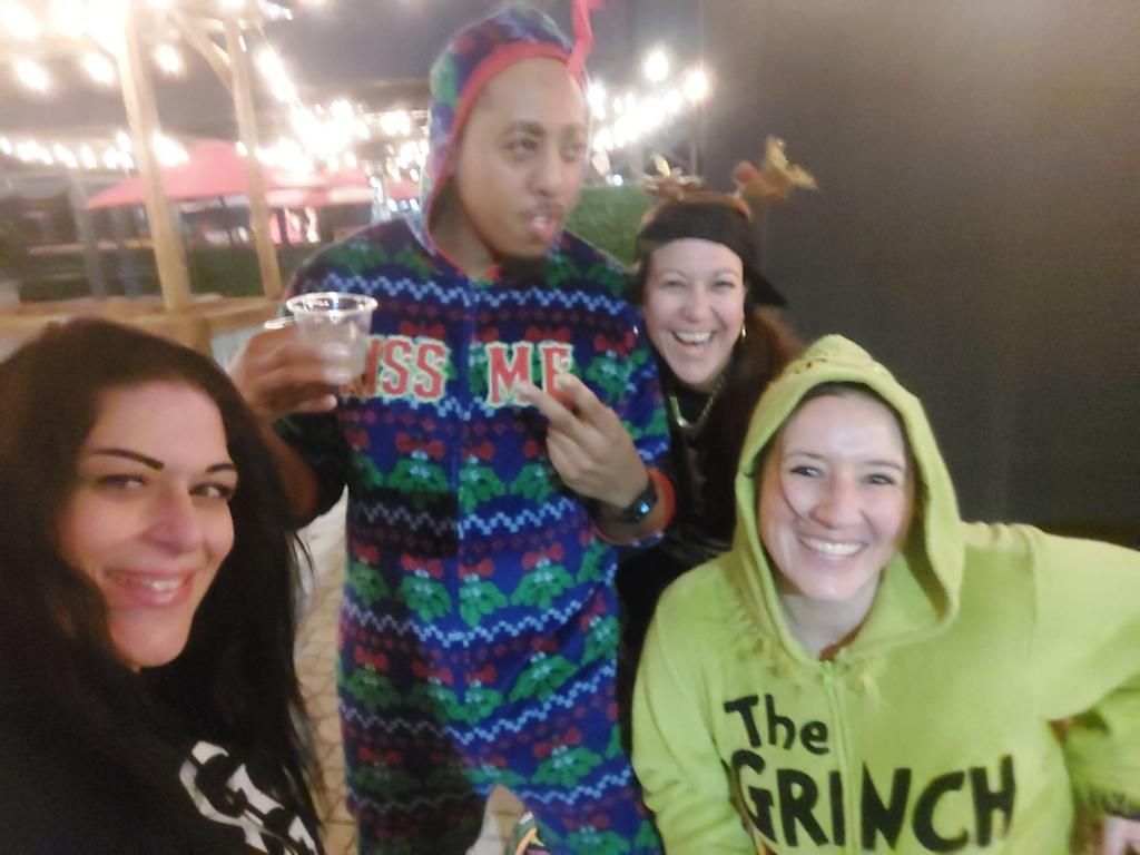 A group of people posing for a picture with one wearing a shirt that says the grinch