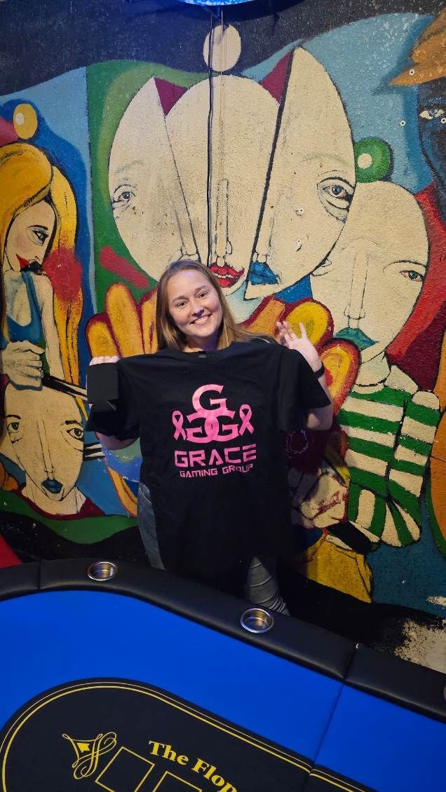 A girl is holding a t-shirt that says grace on it
