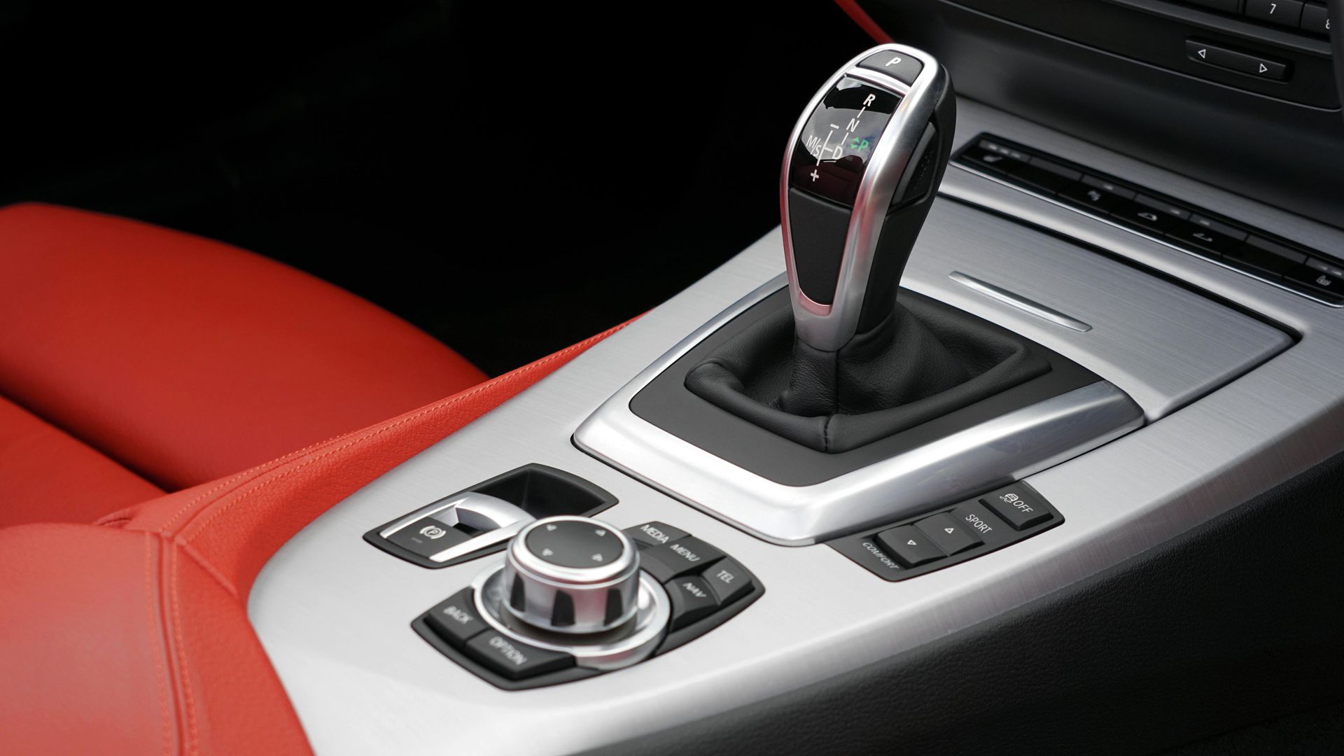 A close up of a car 's shifter and controls