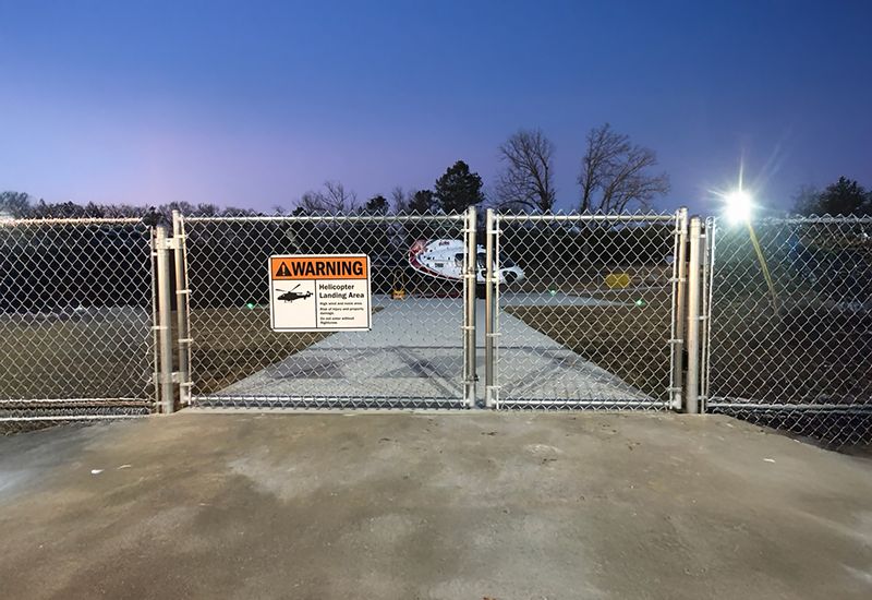 A chain link fence with a warning sign on it.
