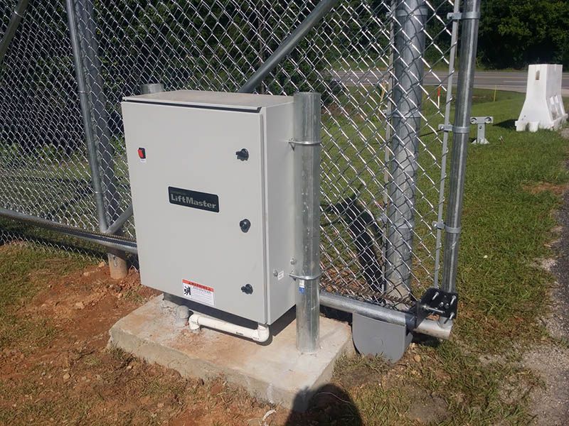A white box is sitting next to a chain link fence