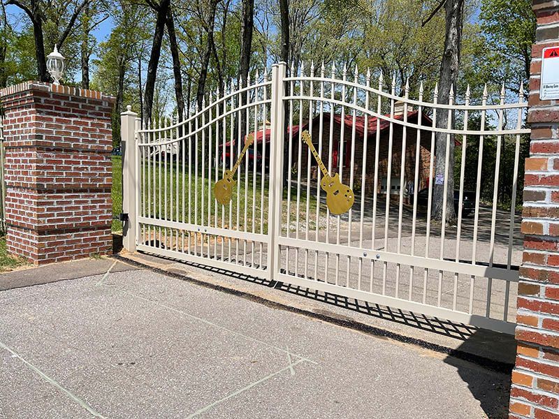 A white gate with two guitars painted on it