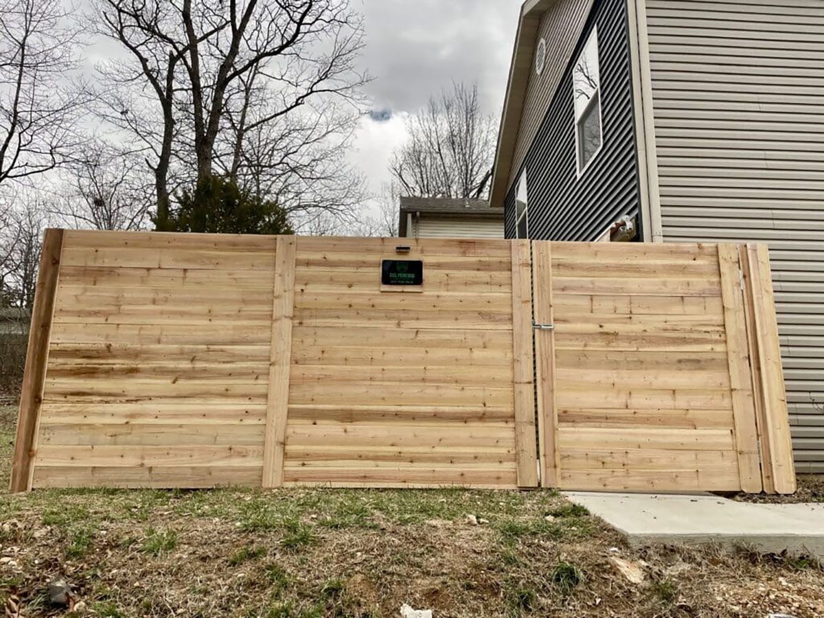 A wooden fence is sitting in front of a house.
