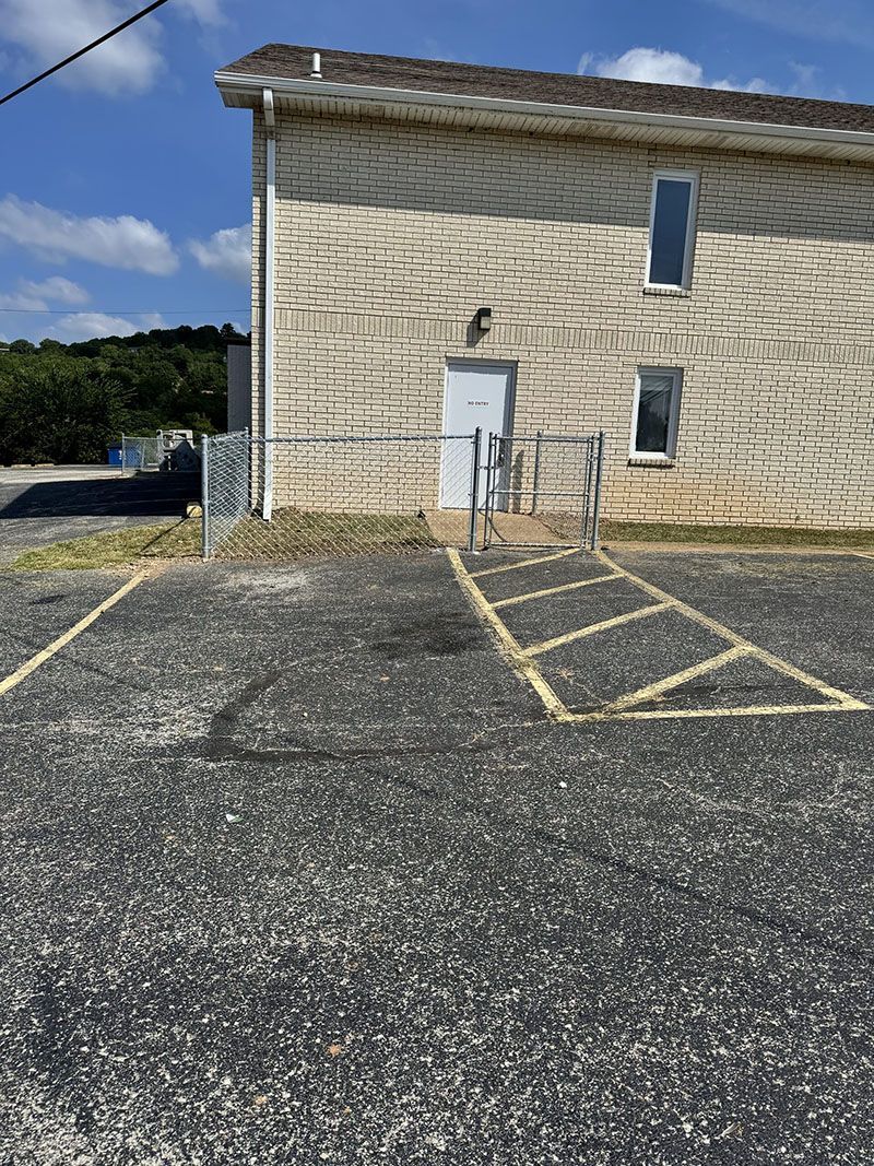 A large brick building with a handicapped parking spot in front of it.