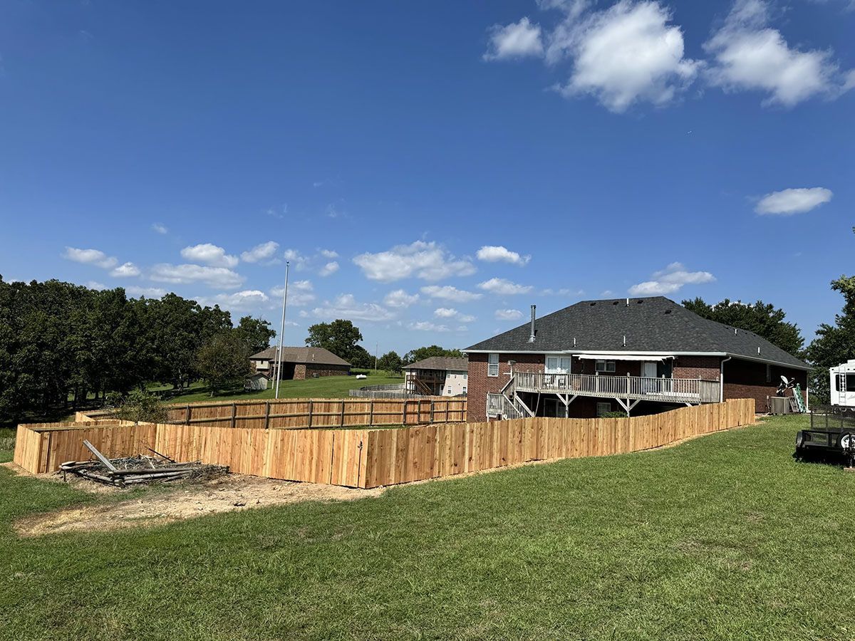 A wooden fence is being built in front of a house.