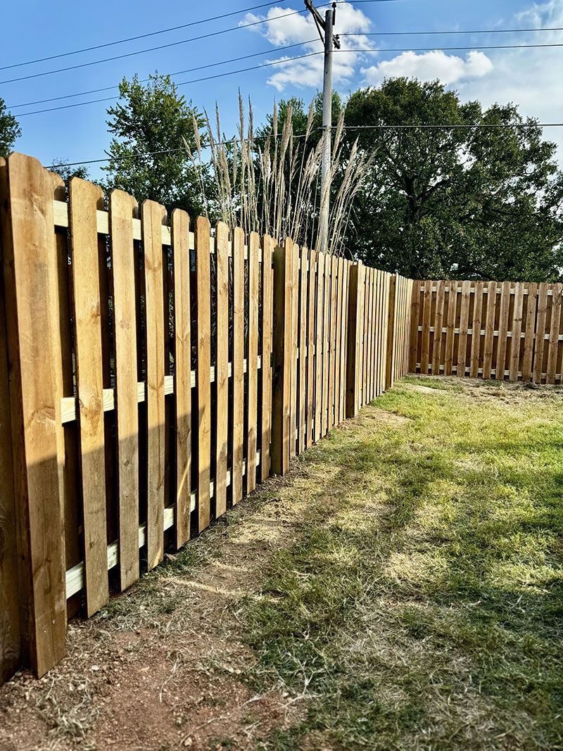 A wooden fence is sitting in the middle of a grassy field.