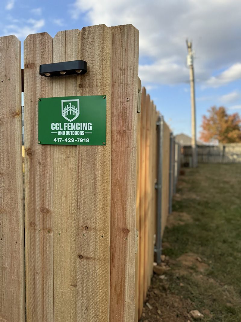 A wooden fence with a green sign on it that says golffencing