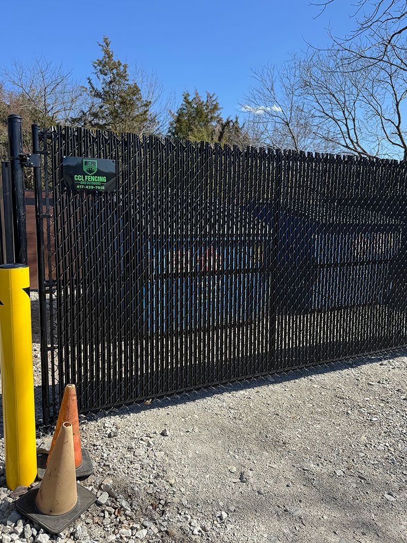 A fence with two traffic cones in front of it