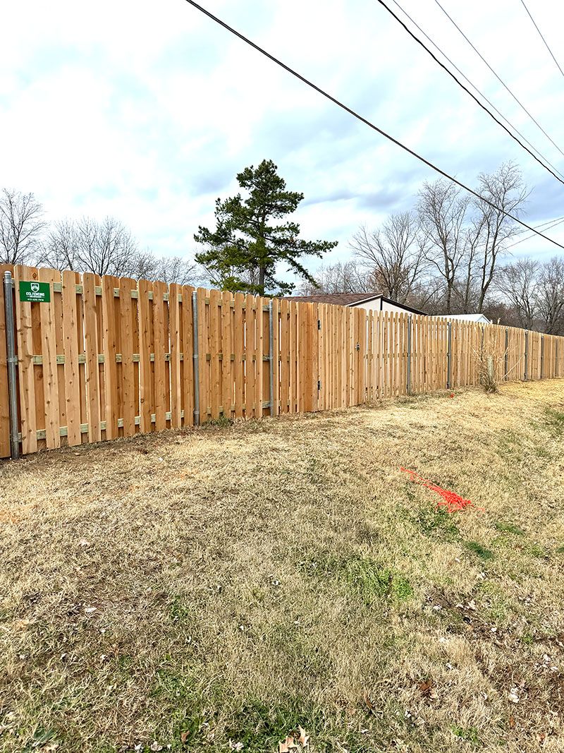 A wooden fence is sitting in the middle of a grassy field.