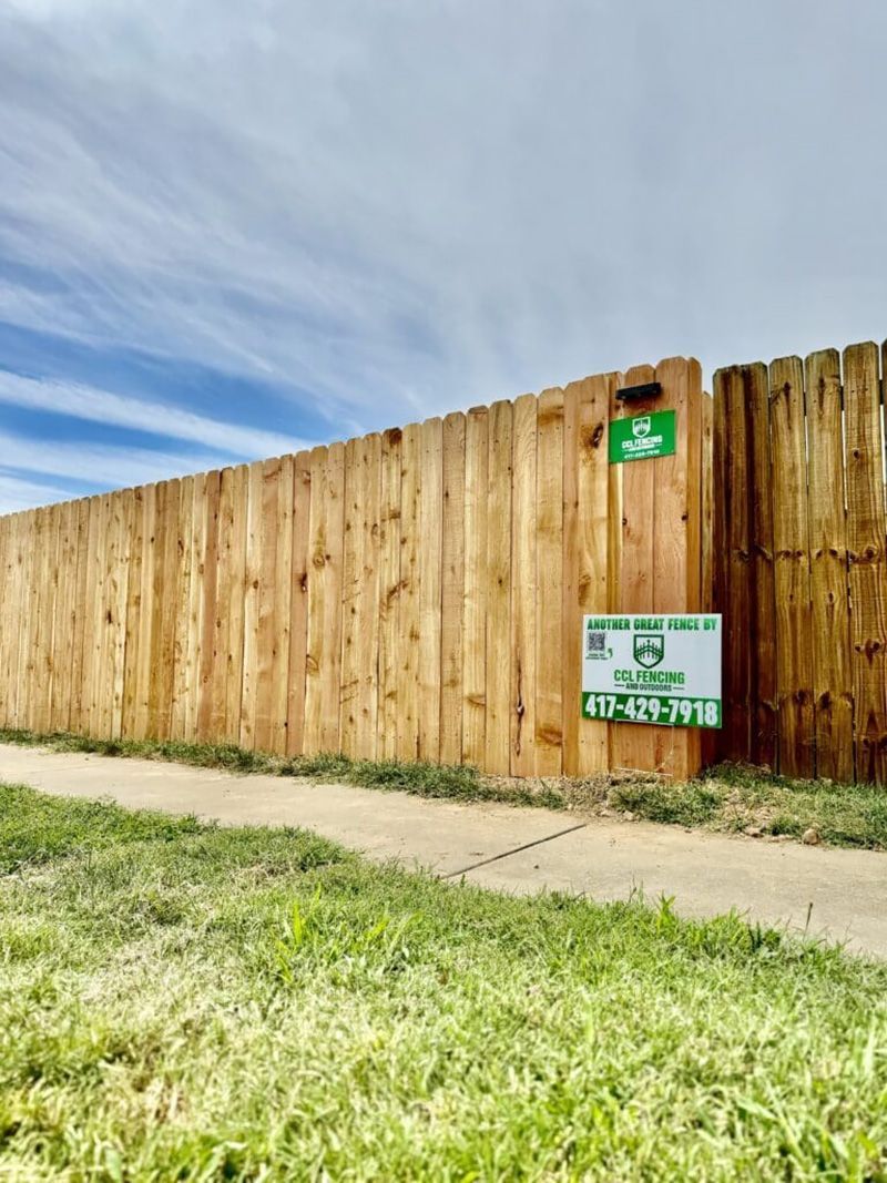 A wooden fence with a sign on the side of it.