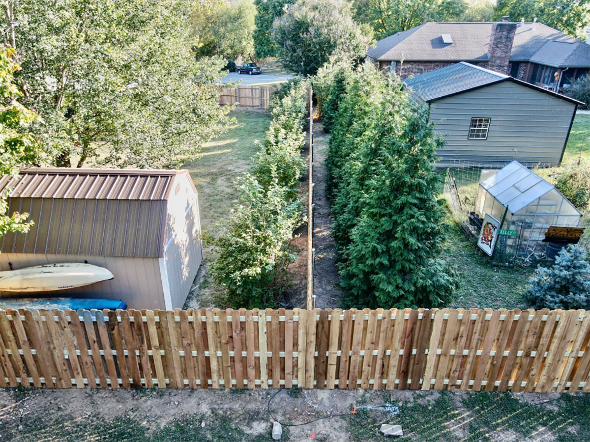 An aerial view of a backyard with a wooden fence and a shed.
