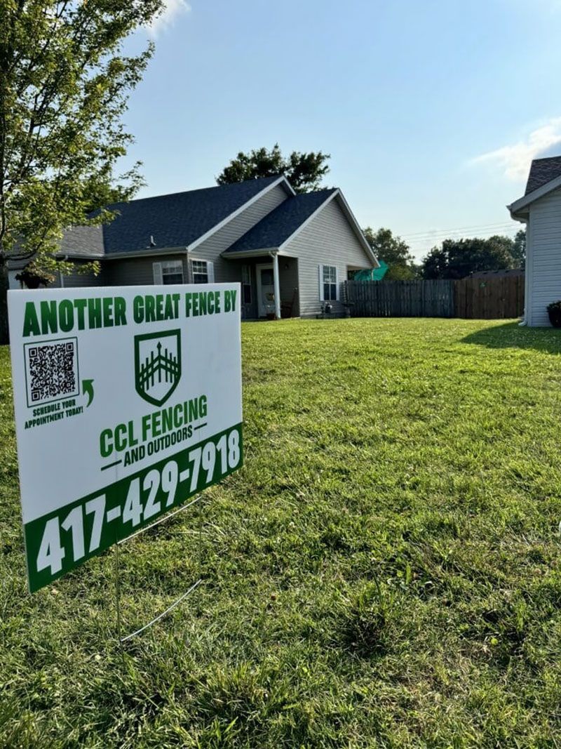 A sign for another great fence is in the grass in front of a house.