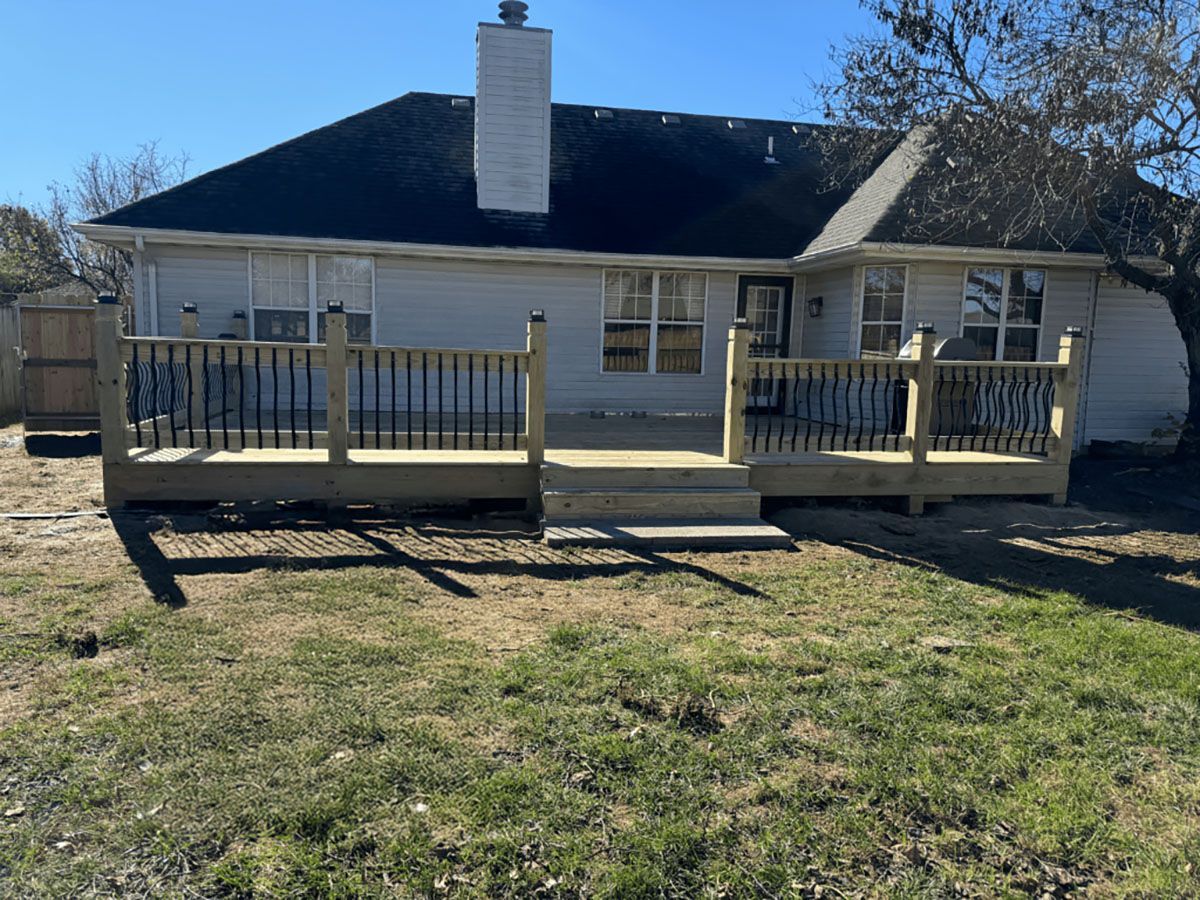 A house with a large wooden deck in front of it.