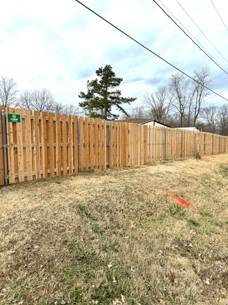 A wooden fence is sitting in the middle of a grassy field.
