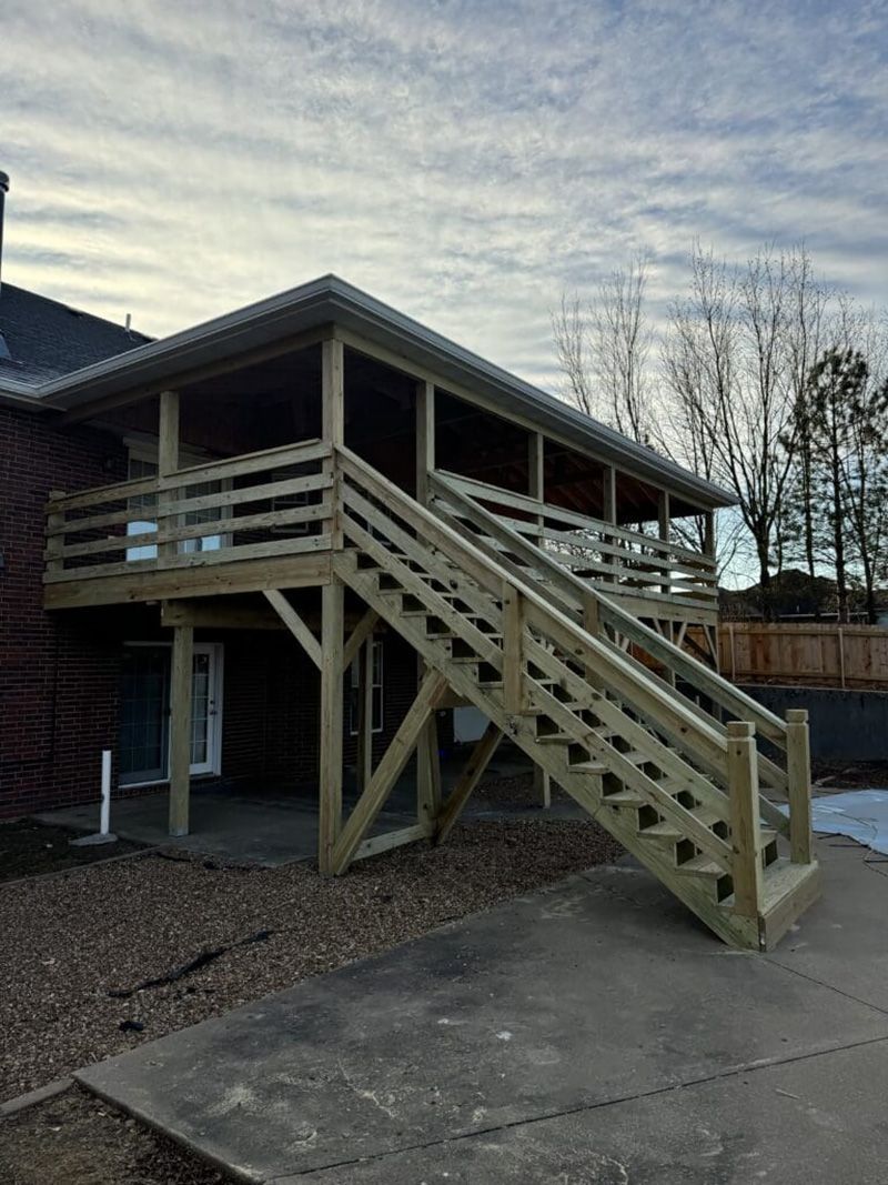 A house with a wooden deck and stairs leading up to it.