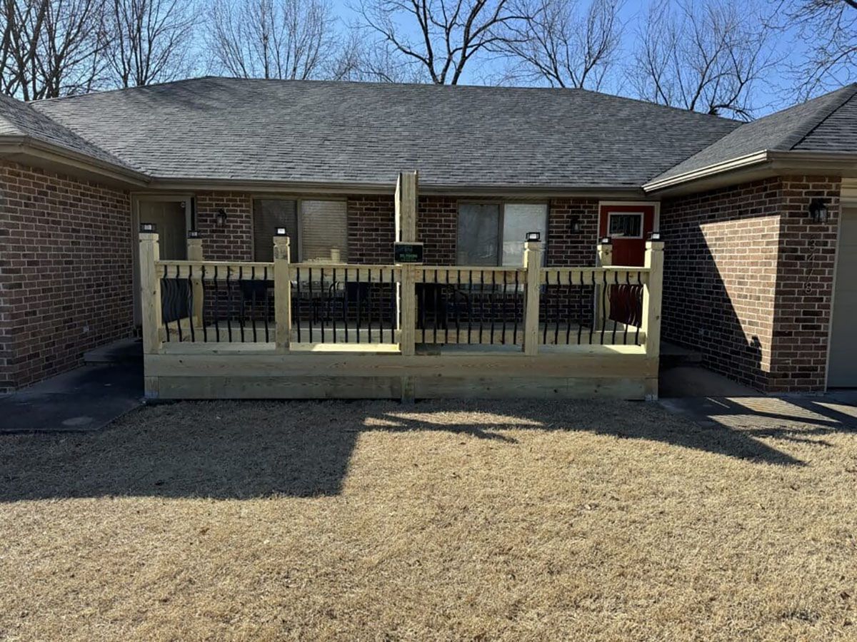 A brick house with a wooden deck in front of it.