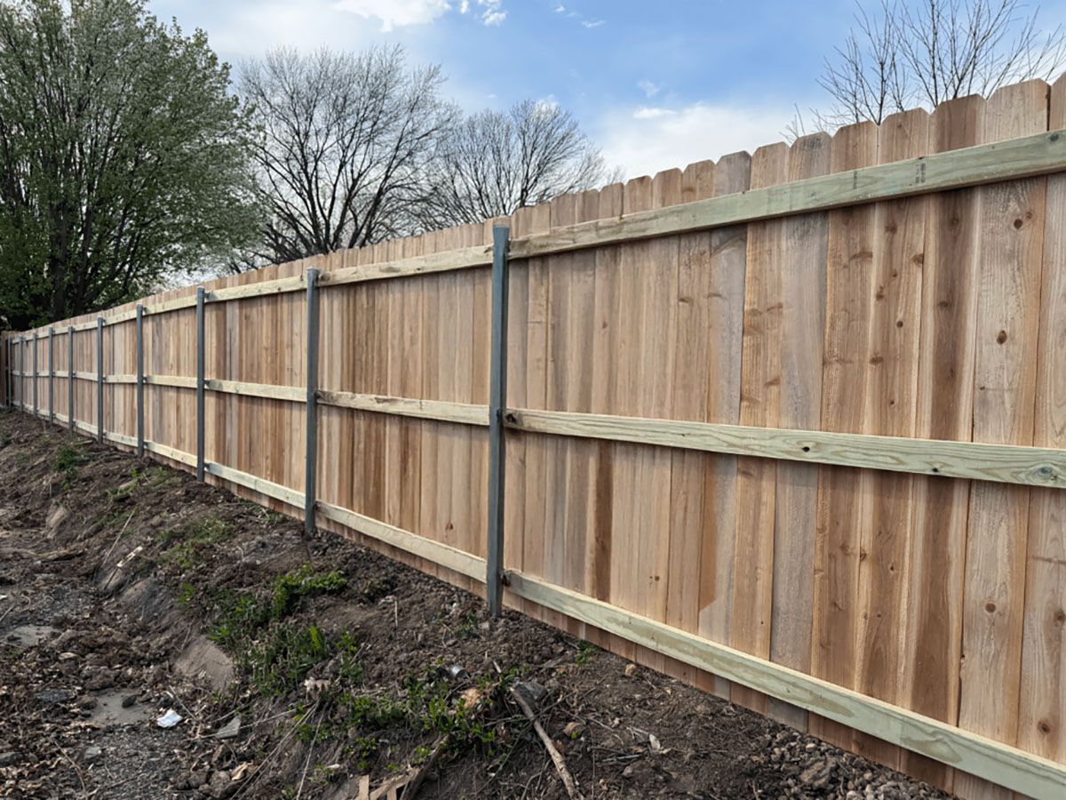 A wooden fence is sitting on top of a dirt hill.