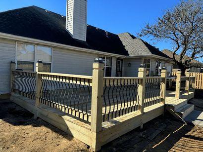 A wooden deck is sitting in front of a house.