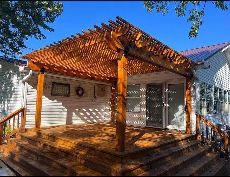 A wooden deck with a pergola on top of it