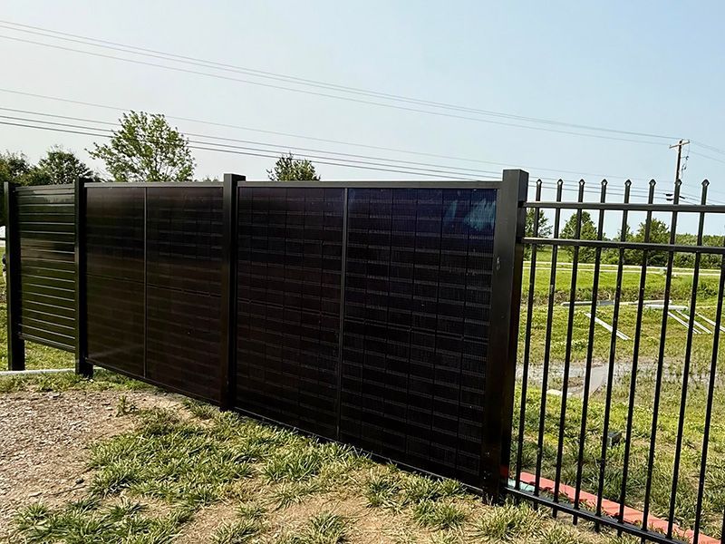 A black fence with a solar panel on it