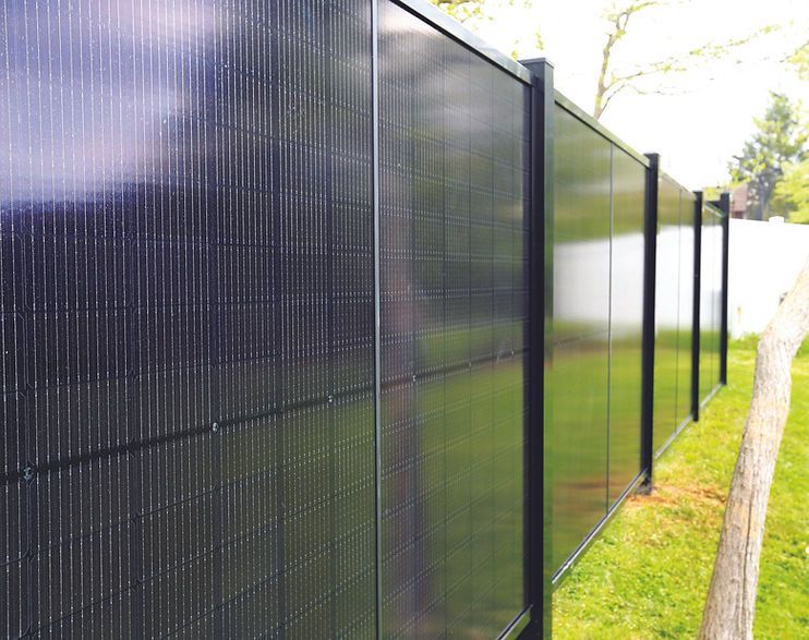 A fence with a lot of solar panels on it.