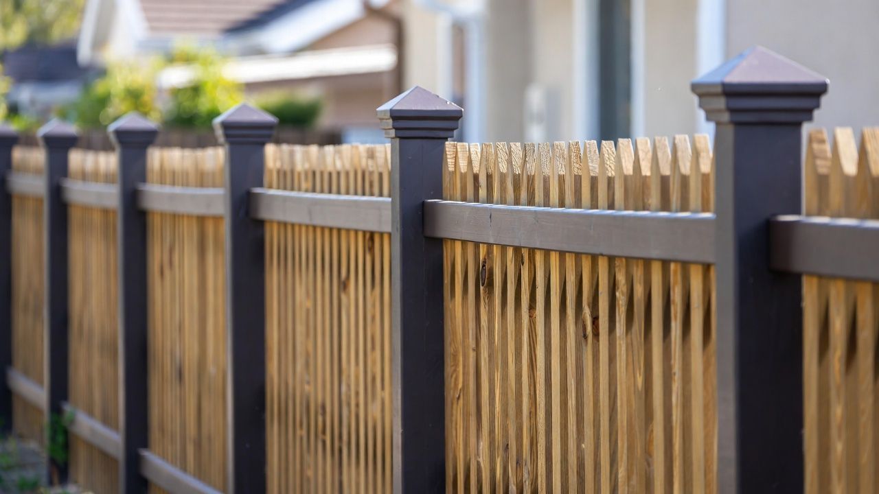Brown and black fence with vertical bamboo slats.