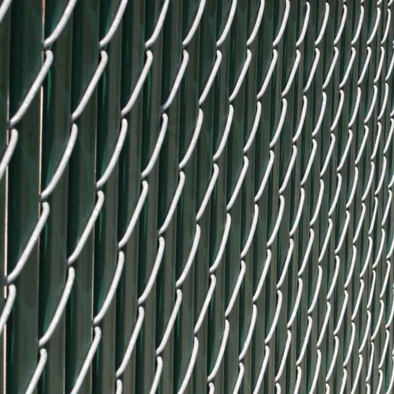 A close up of a chain link fence with a green background.