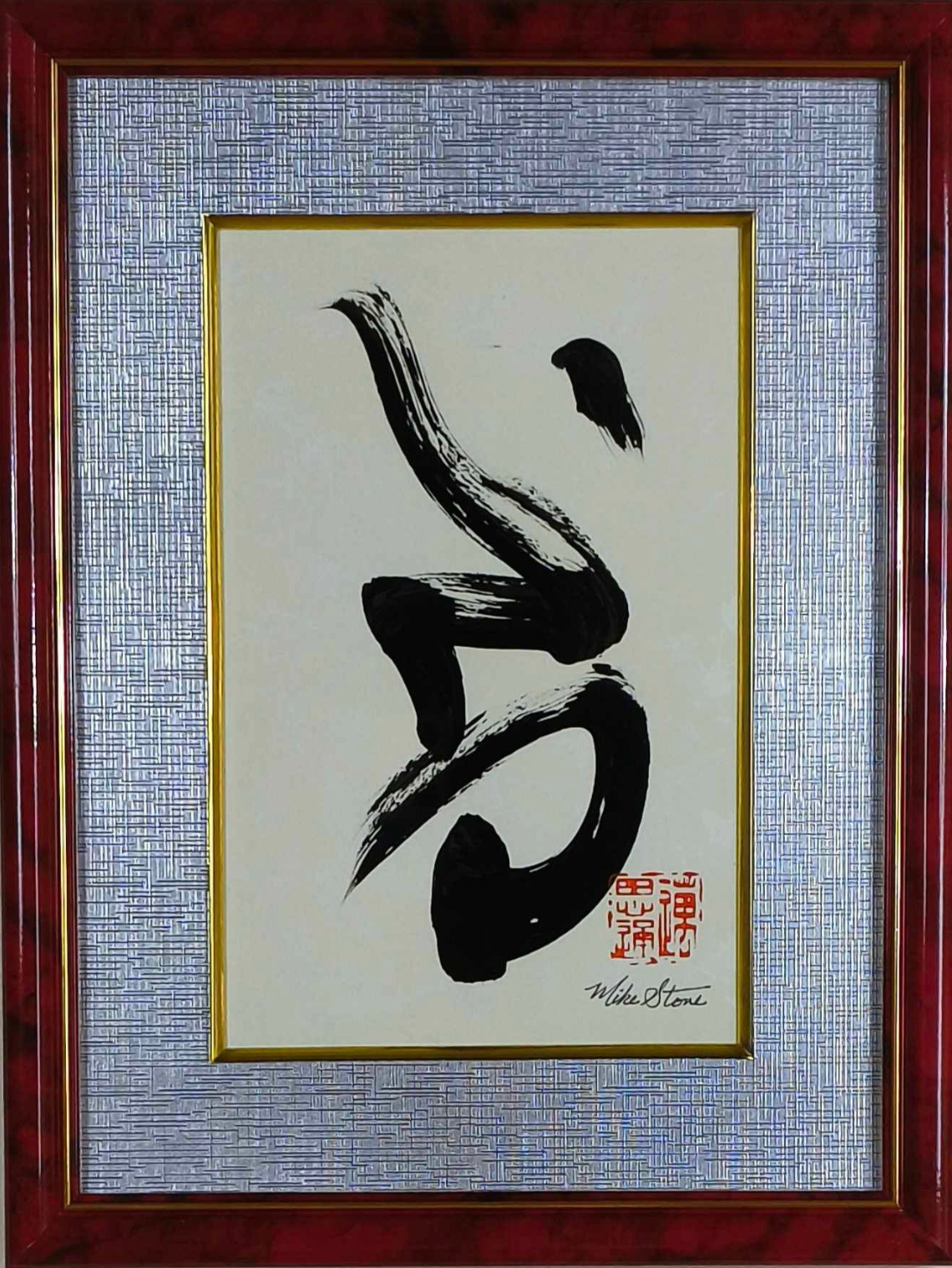 Framed abstract calligraphy art; black ink brushstrokes on cream paper. Red frame with silver and gold accents.