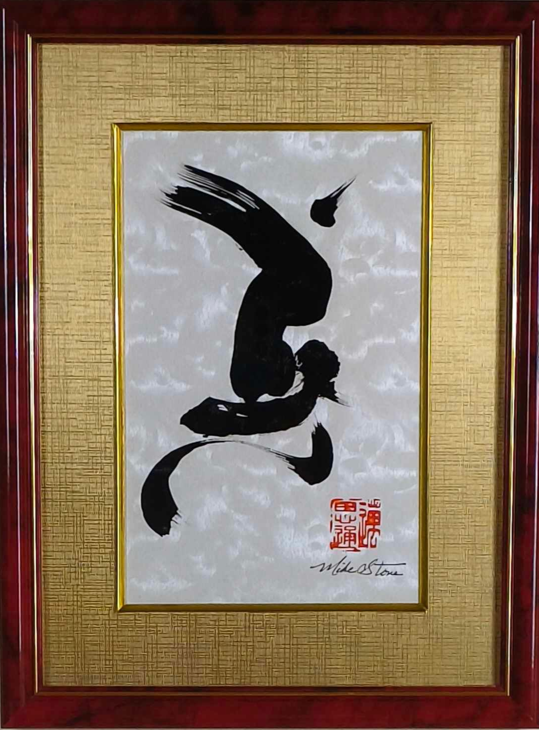 Framed artwork featuring a calligraphic black character on a textured white and gold background, with a red frame.