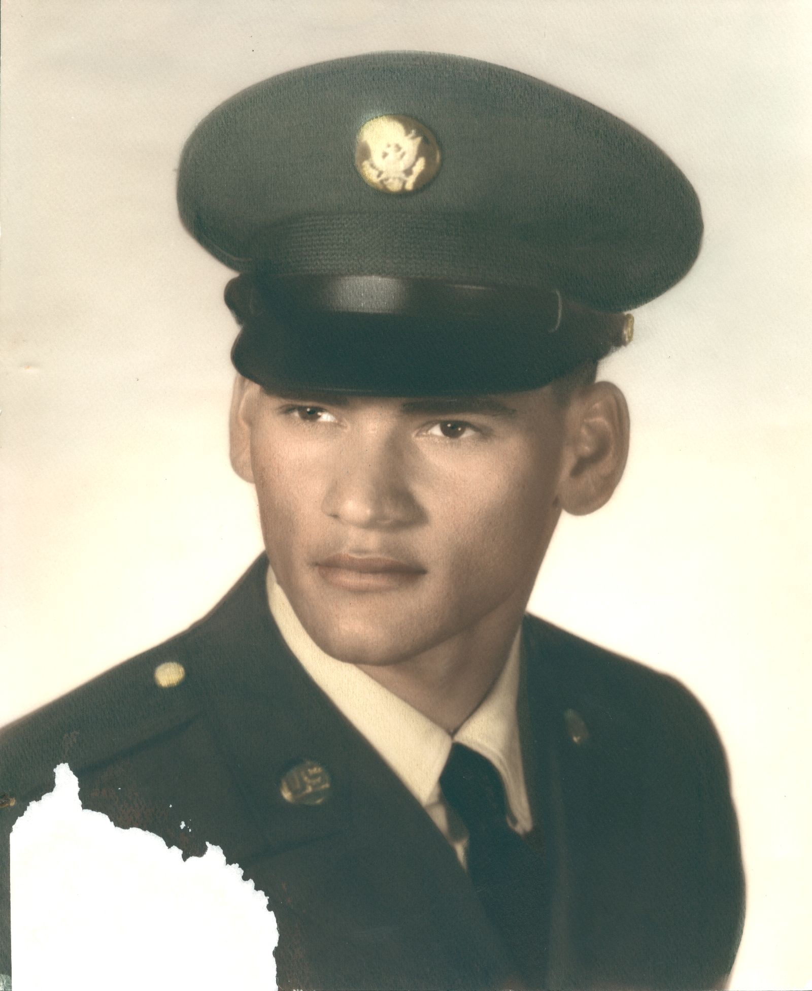 Man in military uniform, wearing a hat with a gold emblem, looking to the side with a serious expression.