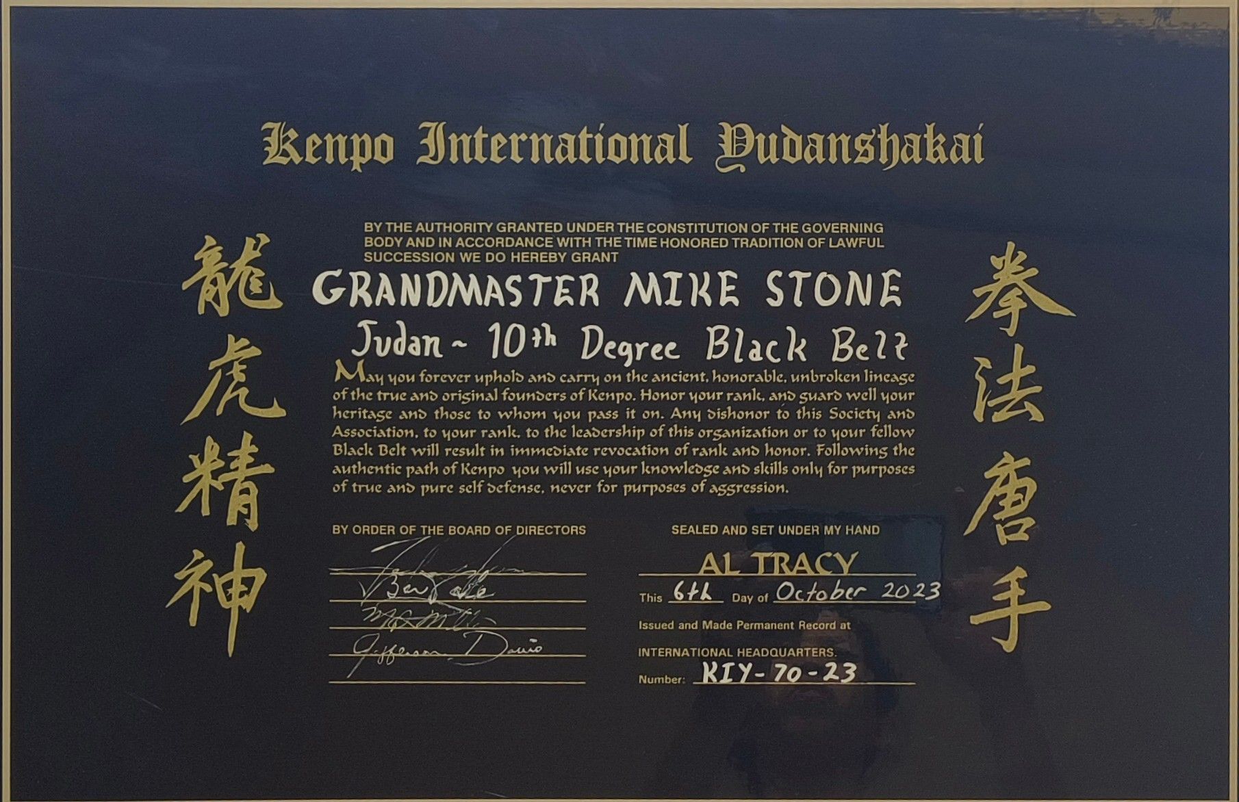 Certificate for Grandmaster Mike Stone, Judo 10th Degree Black Belt, with gold text on a blue background. 
