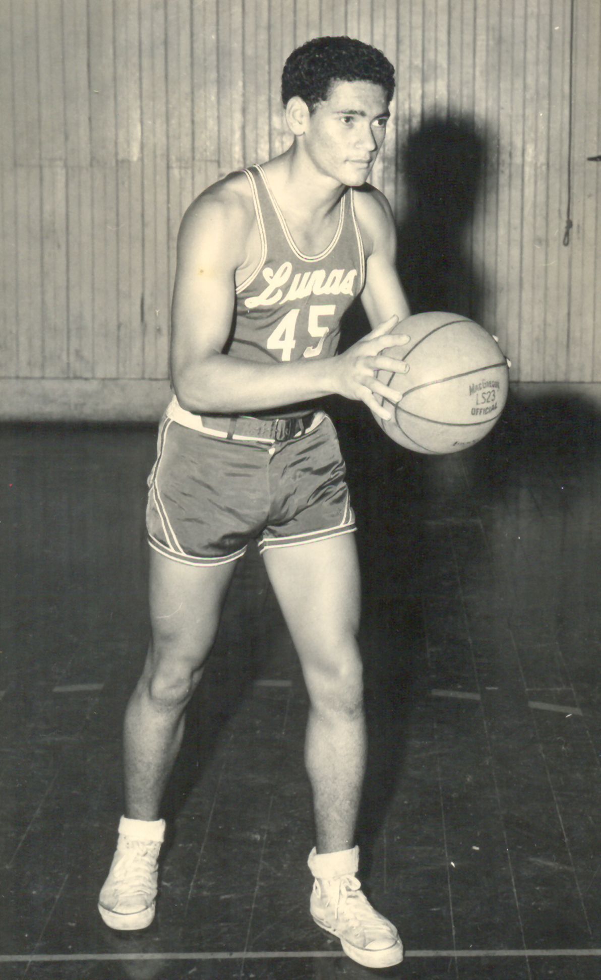 Basketball player in a red and white uniform, number 45, holding the ball on a wooden court.