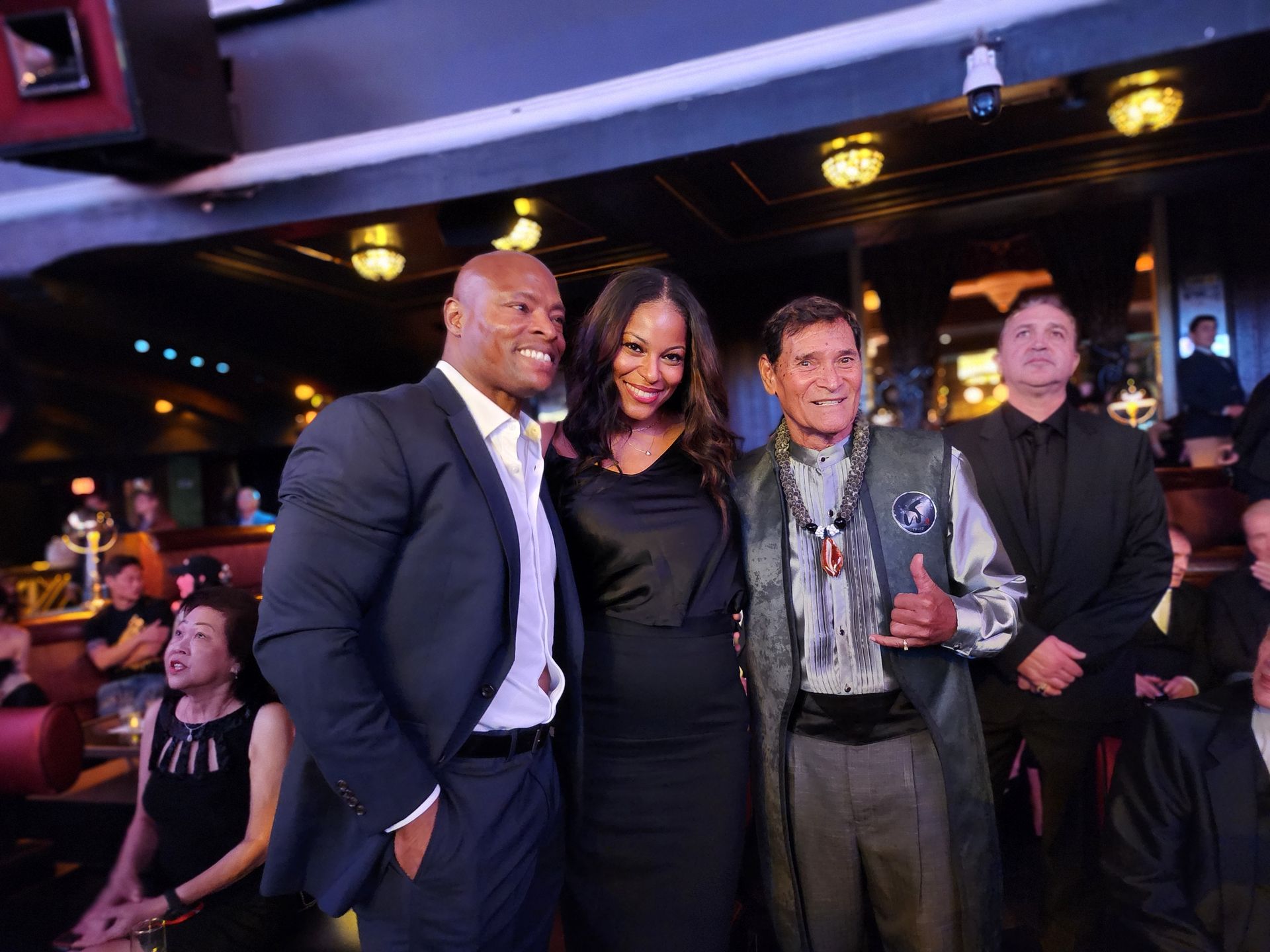 Three people pose for a photo in a dimly lit venue.