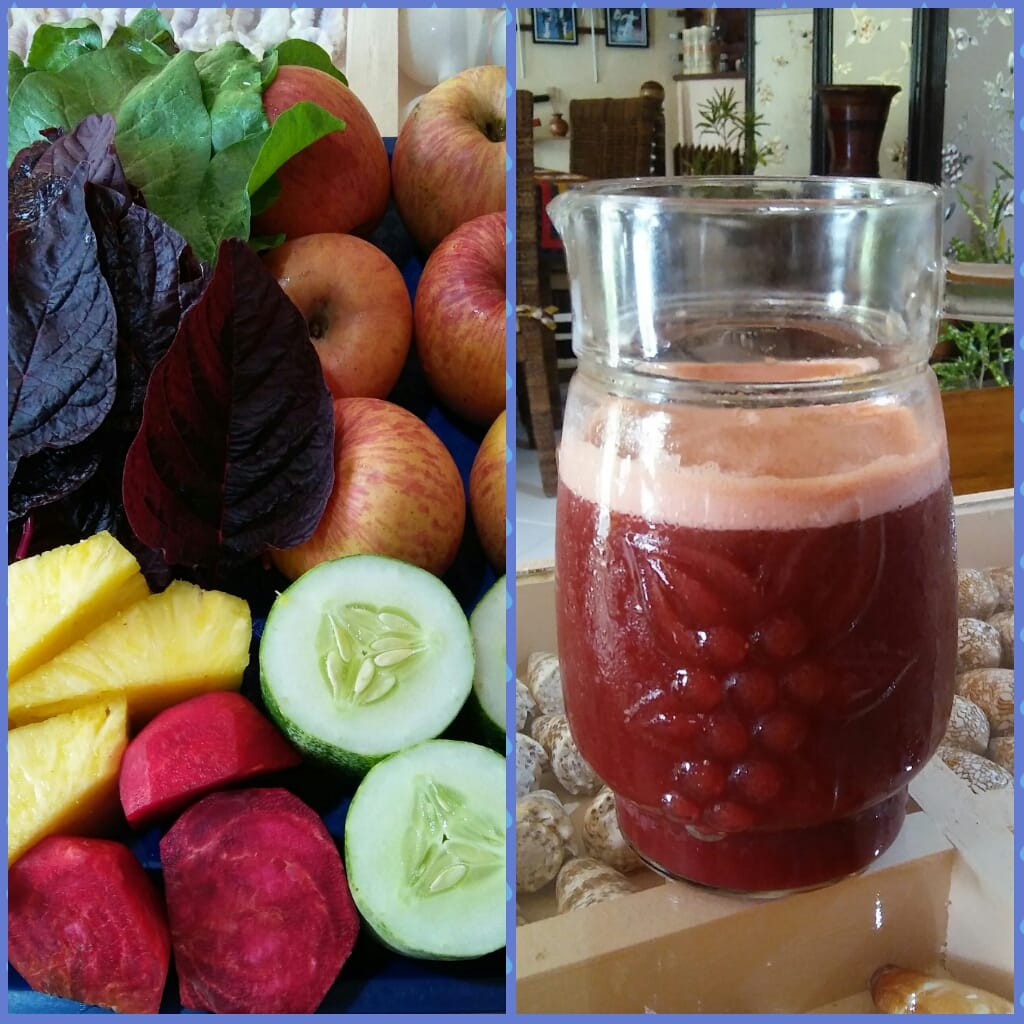 Fresh produce alongside a pitcher of juice. Includes apples, beets, spinach, cucumber, and pineapple.