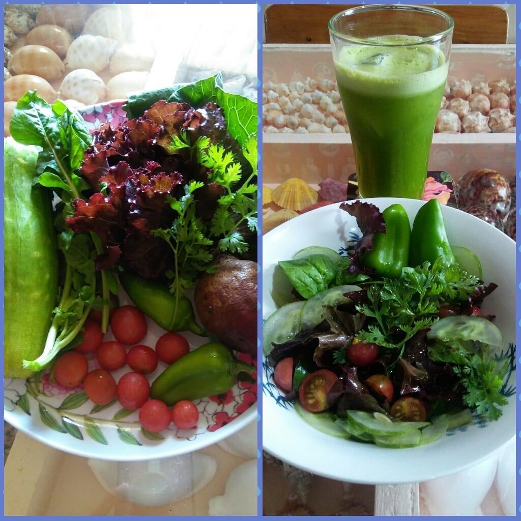 Fresh vegetables, cherry tomatoes, and green juice on a table. A salad is also present.