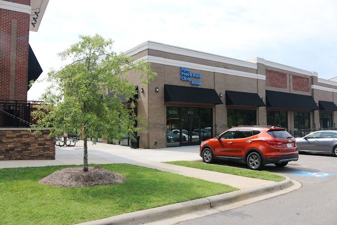 A red suv is parked in front of a brick building.