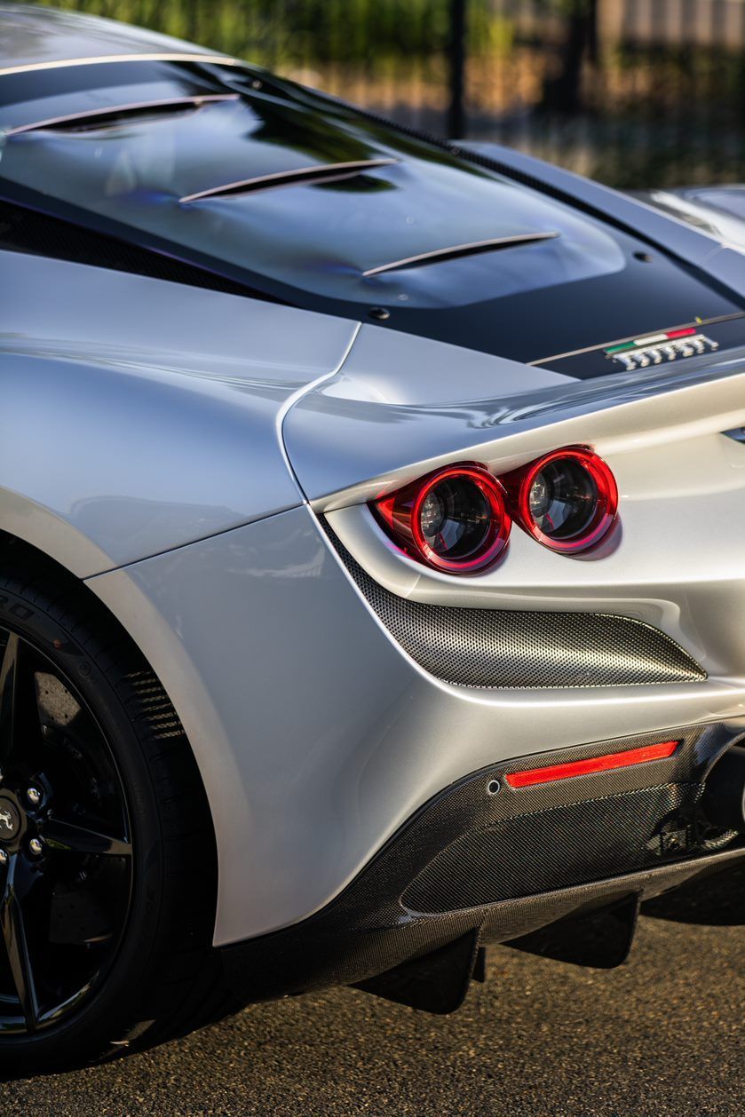 White Ferrari sports car rear with red taillights and black accents.