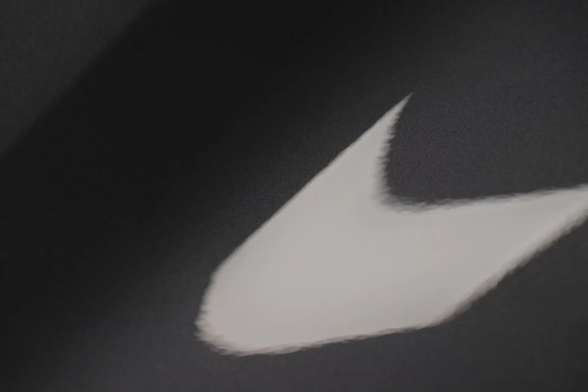 White Nike swoosh logo on a dark gray background.
