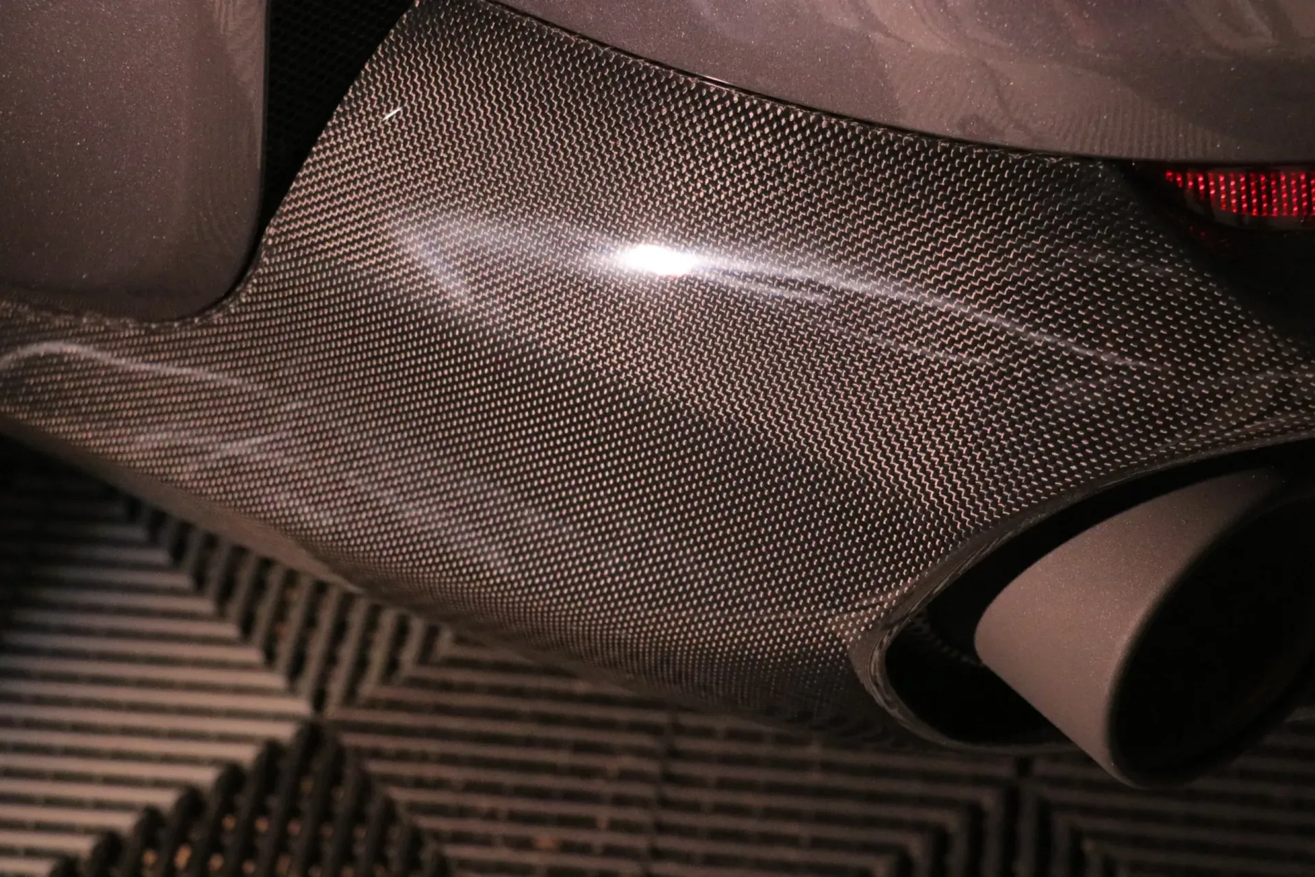 Carbon fiber car exhaust component with two outlets.