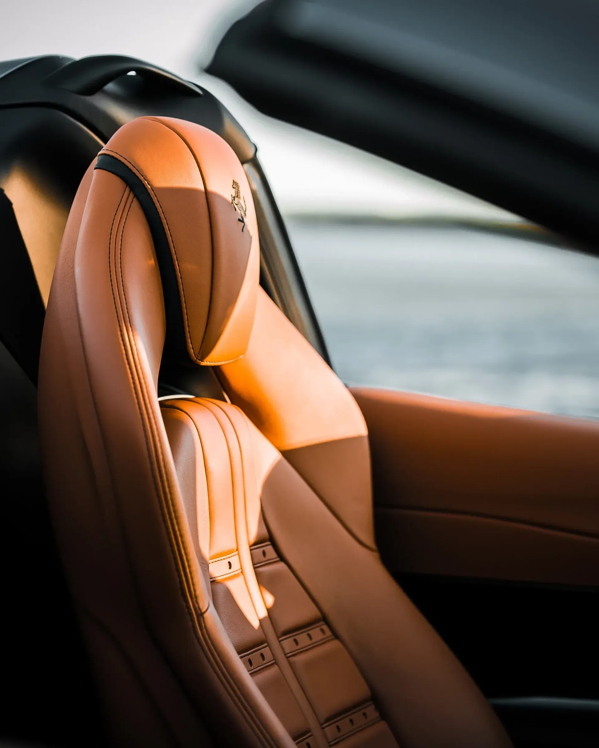 Tan leather car seat with headrest, close-up.