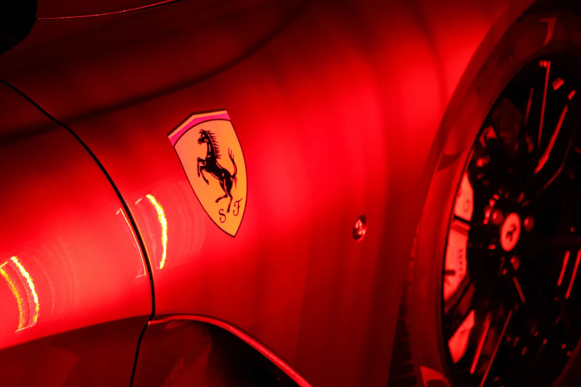 Ferrari emblem on a red car; black prancing horse on a yellow shield.