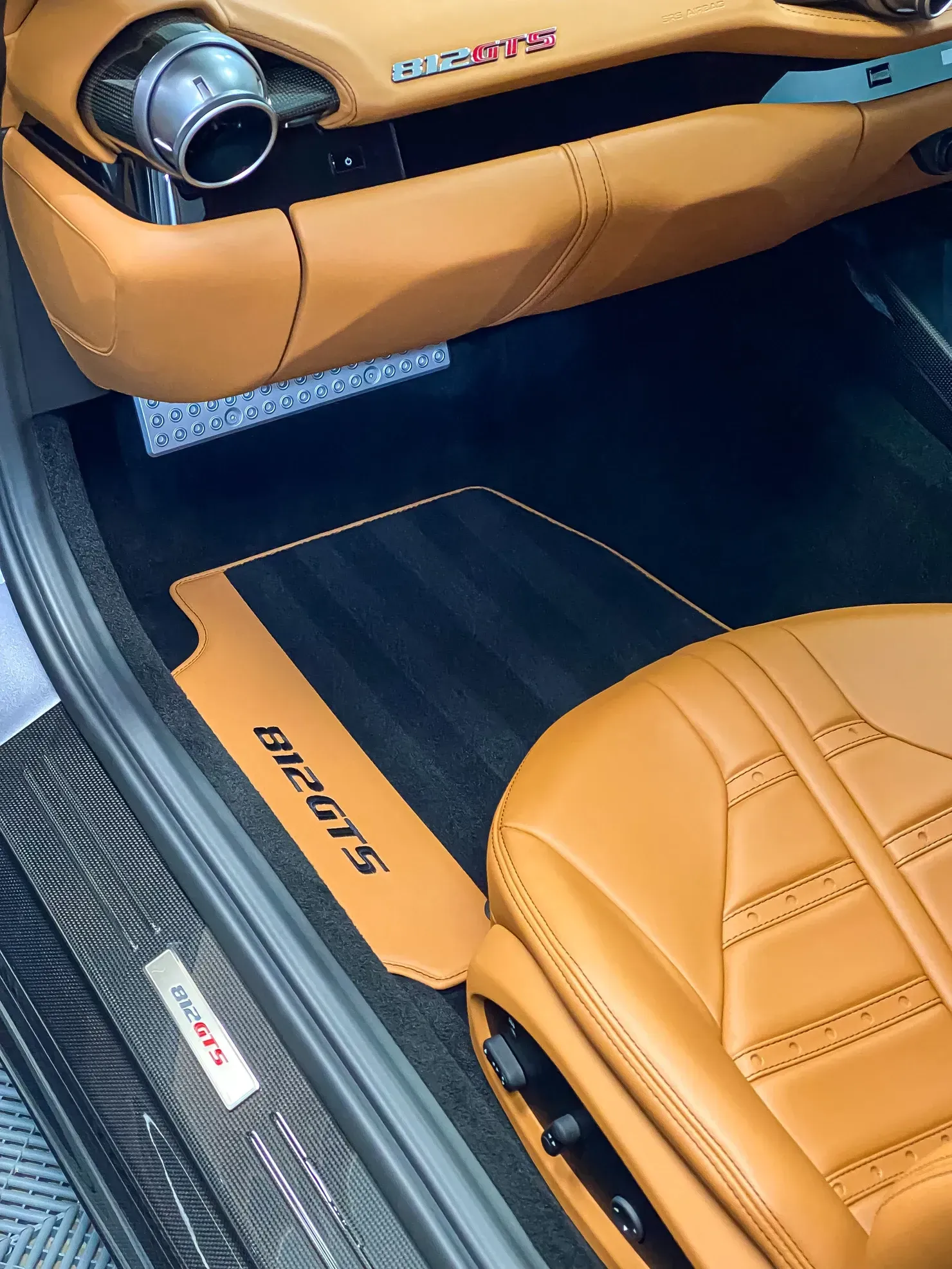 Tan and black car interior with leather seats, floor mat with 