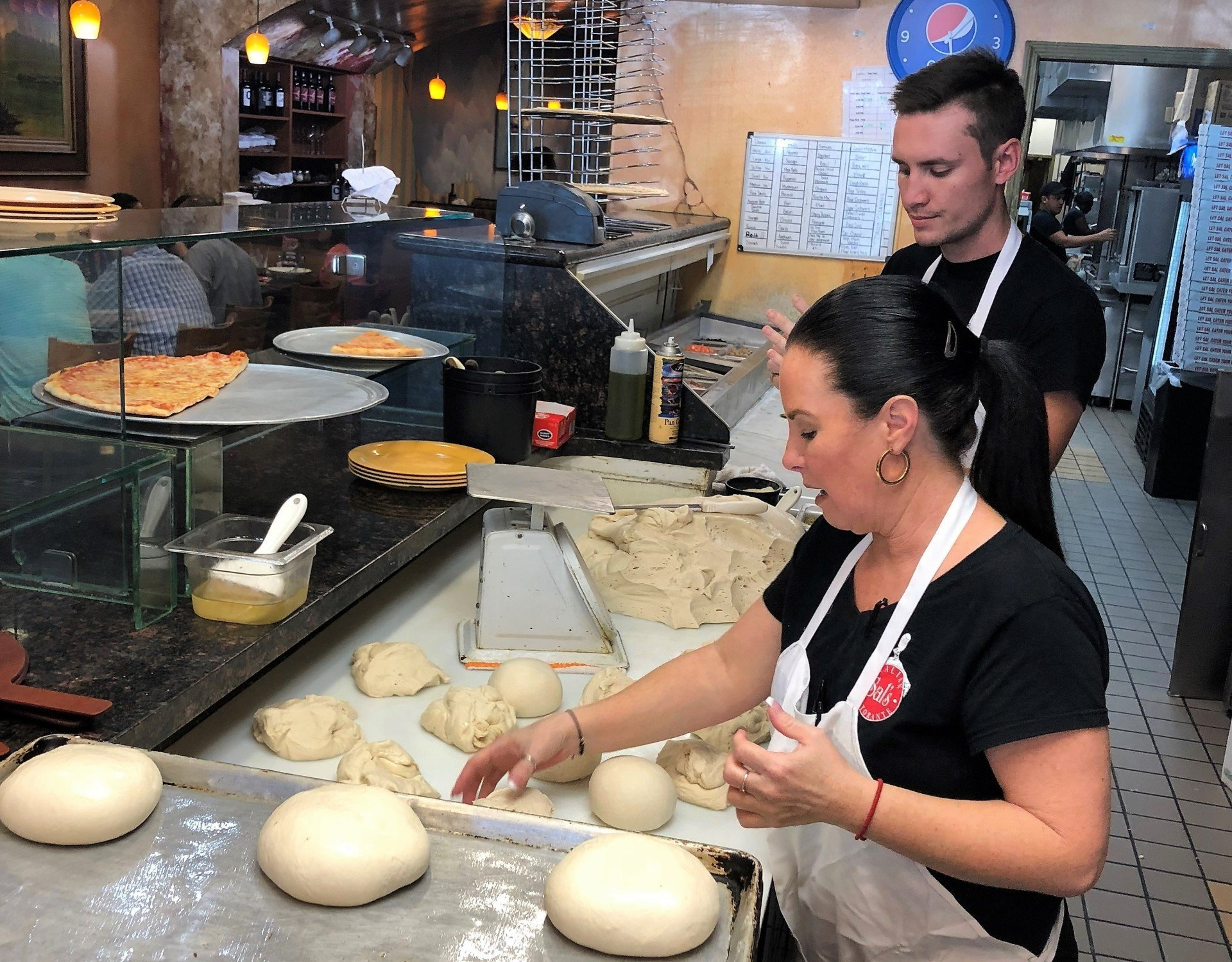 Workers making pizza dough