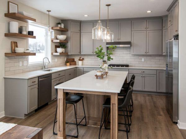 Modern kitchen with gray cabinets, white countertops, and wood accents.