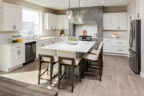 Bright modern kitchen with white cabinets, a large island, and seating.