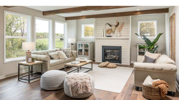 Cozy living room with a fireplace, neutral tones, large windows, and wood beams.