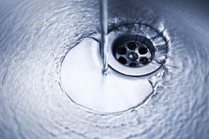 A close up of water running down a sink drain.