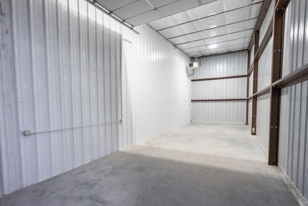 A large empty warehouse with white walls and a concrete floor.