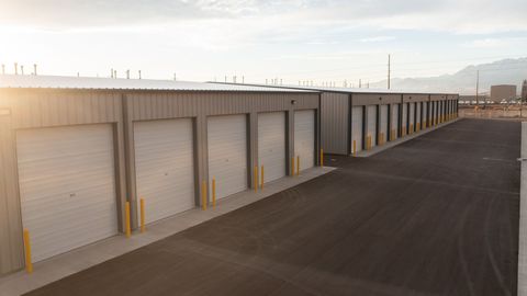 A row of garage doors are lined up in a parking lot.