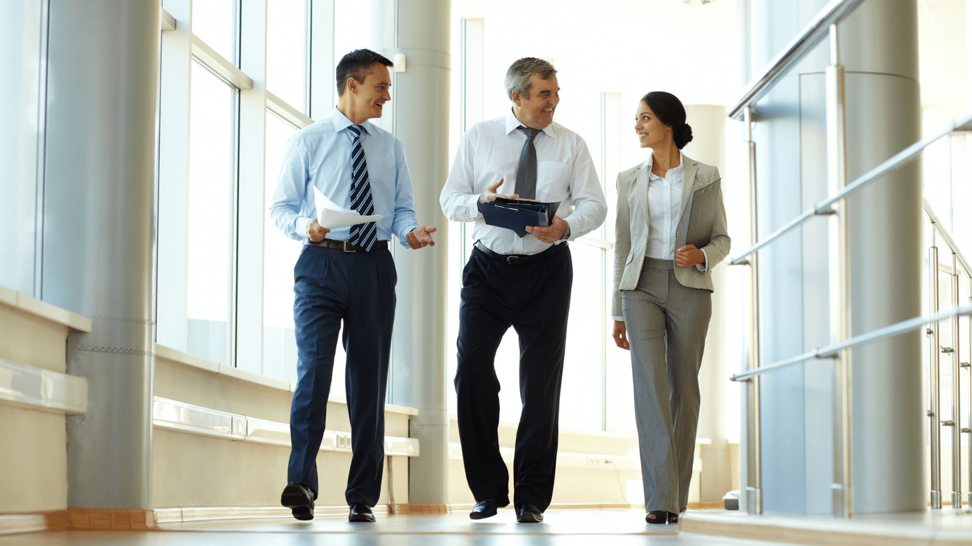 A group of business people are walking down a hallway.